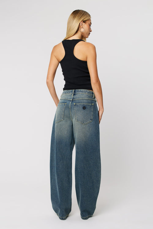 Woman wearing dark wash denim blue jeans with wide leg 