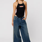 Woman wearing dark wash baggy jeans with a side stripe