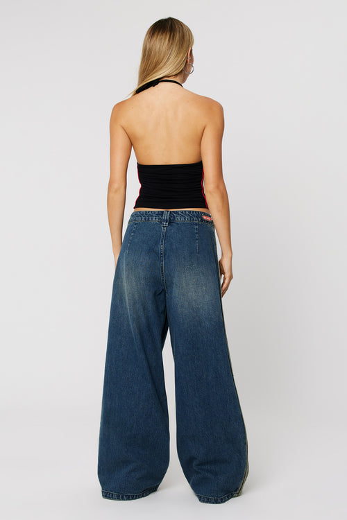 Woman wearing dark wash baggy jeans with a side stripe