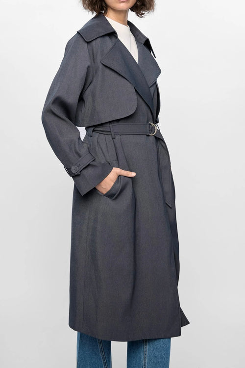 Model wears a grey trench coat with large collar
