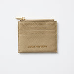 Beige cardholder with gold zipper on a light gray background