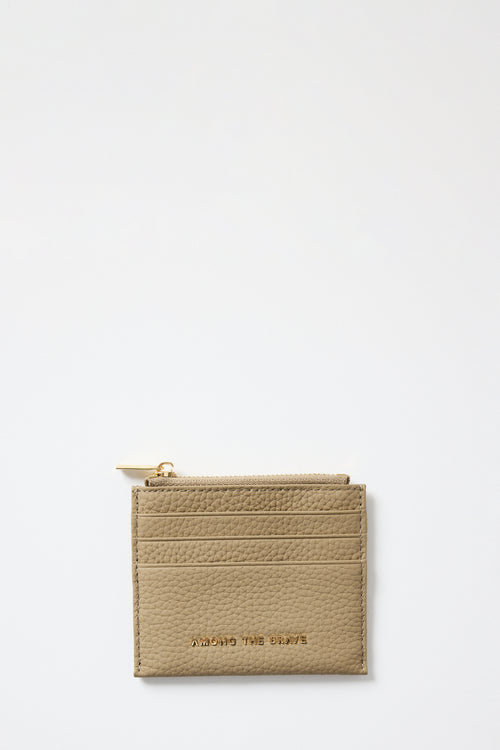 Beige cardholder with gold zipper on a light gray background