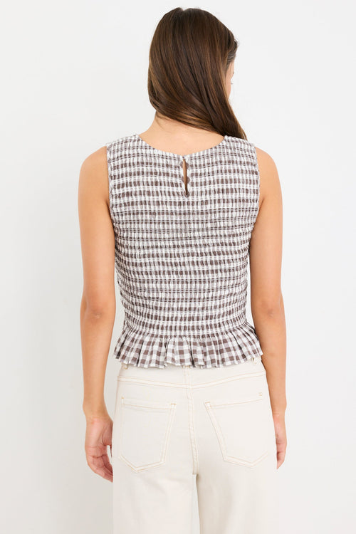 Chocolate gingham sleeveless shell top with frill hem, styled with cream jeans