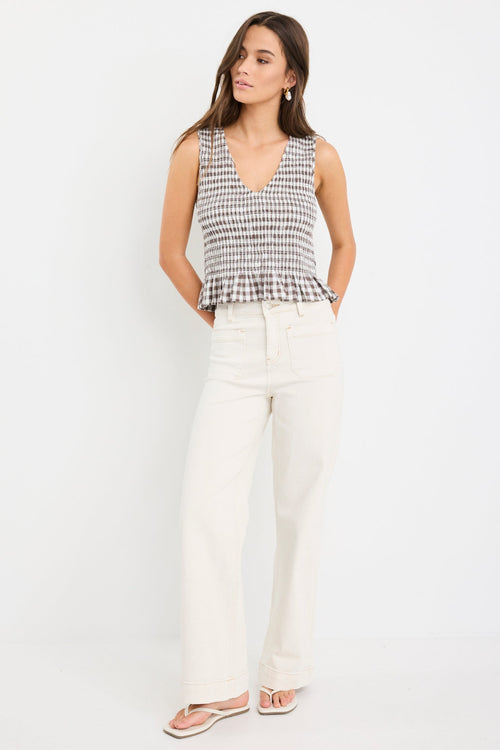 Chocolate gingham sleeveless shell top with frill hem, styled with cream jeans