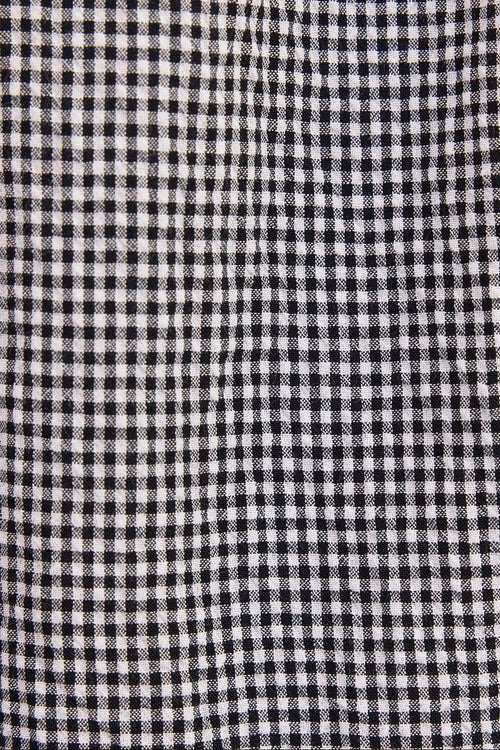 A close-up of a black and white gingham checkered fabric texture.