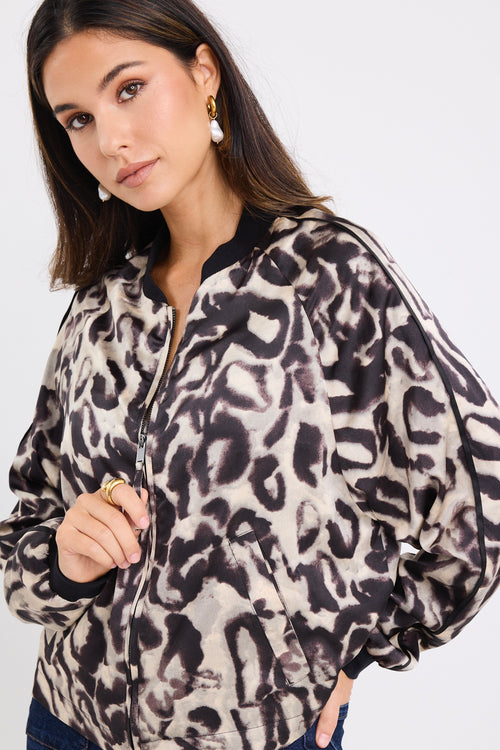 model wears a leopard bomber jacket with dark blue jeans