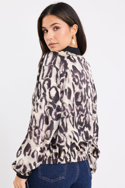 model wears a leopard bomber jacket with dark blue jeans