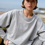 model wears a grey crew sweater