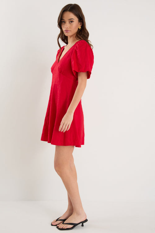Woman wearing a red dress against a white background