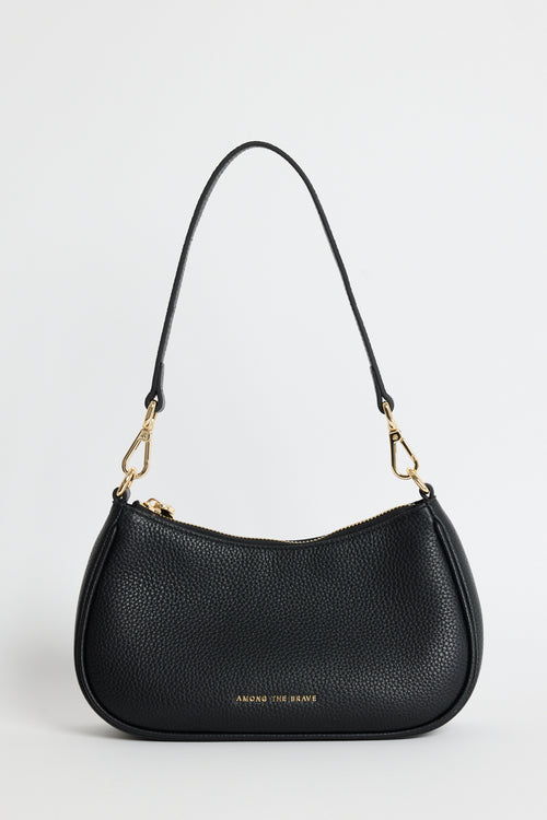 A black pebbled leather crescent-shaped shoulder bag with gold-tone hardware and a small gold logo on the front, photographed against a light gray studio background.