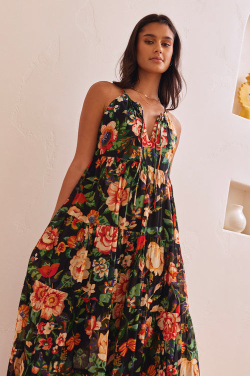 model wears a black floral maxi dress