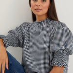 model wearing gingham shirred top. 