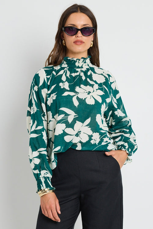 model wears green floral shirred top