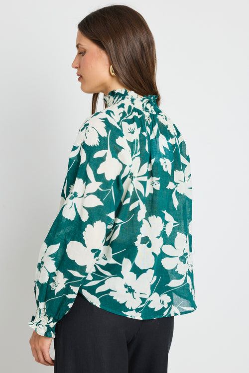 model wears green floral shirred top