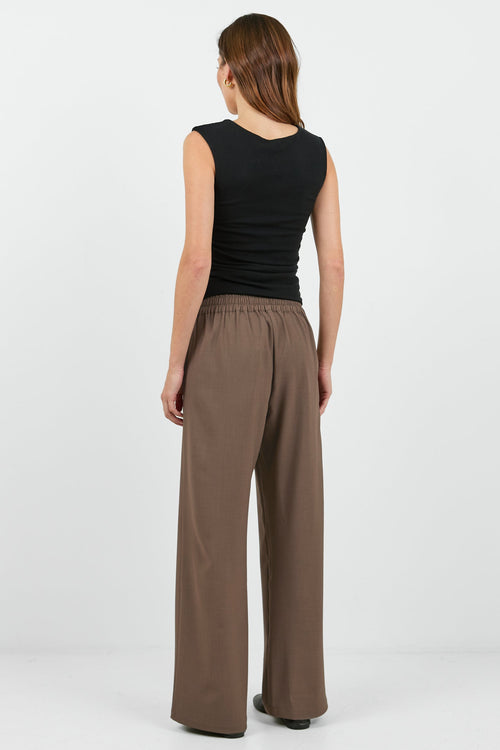 Women wearing black tank and brown pants.