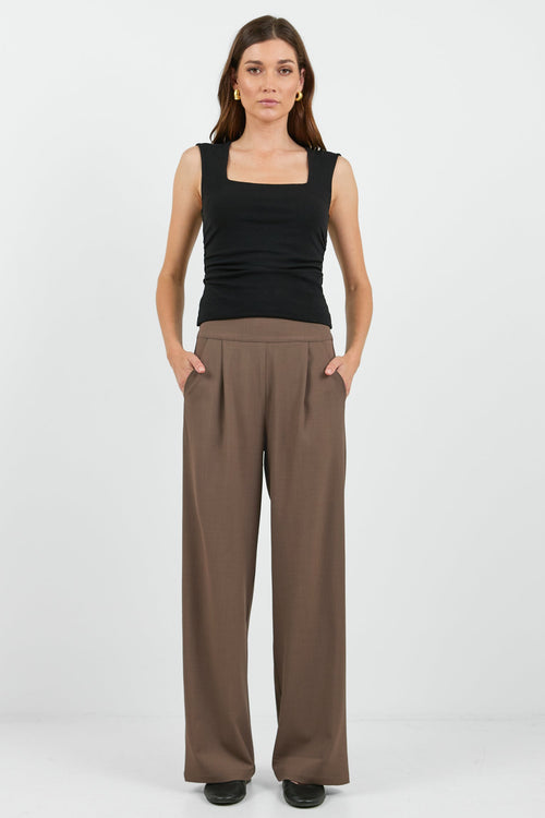 Women wearing black tank and brown pants.