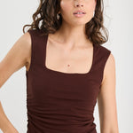 woman wearing a brown ruched top