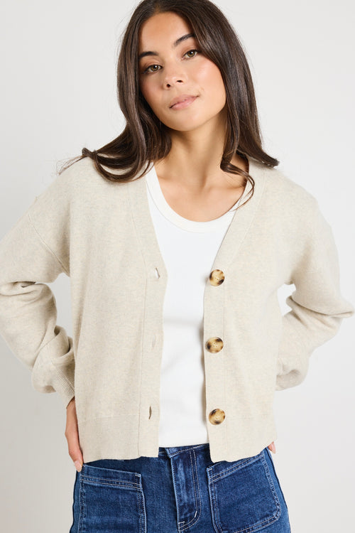 model wears a beige cardigan