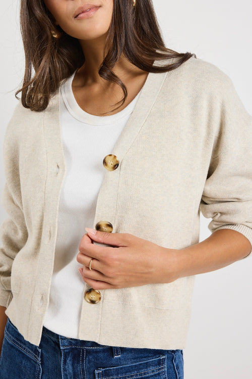 model wears a beige cardigan