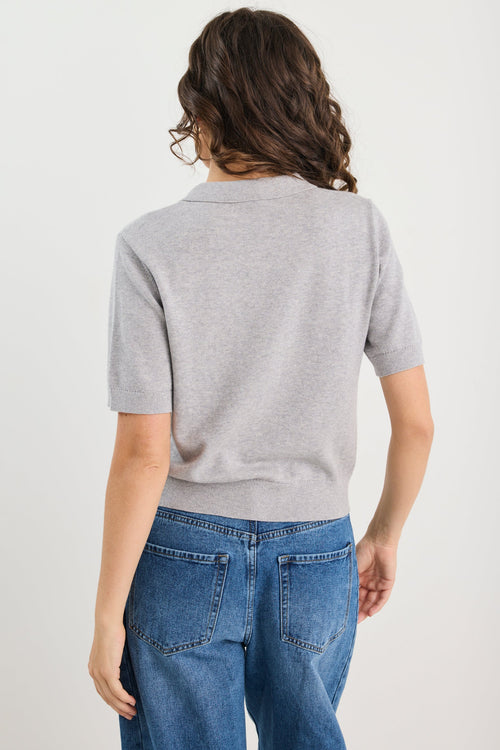 Woman wearing grey knit and blue jeans