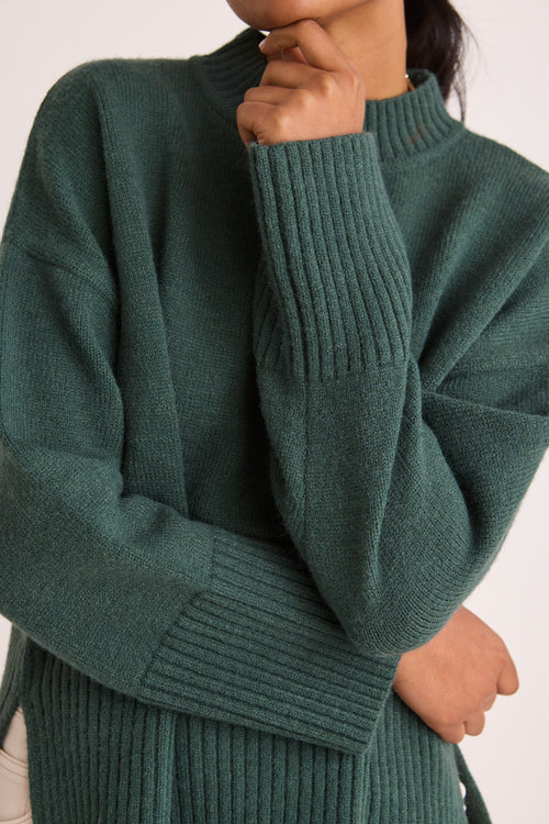 model wears a green knit jumper