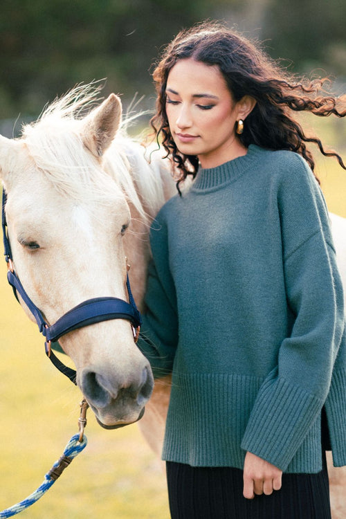 model wears a green knit jumper