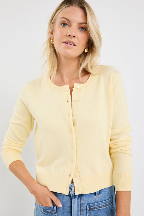 model wears a yellow cardigan with light blue jeans