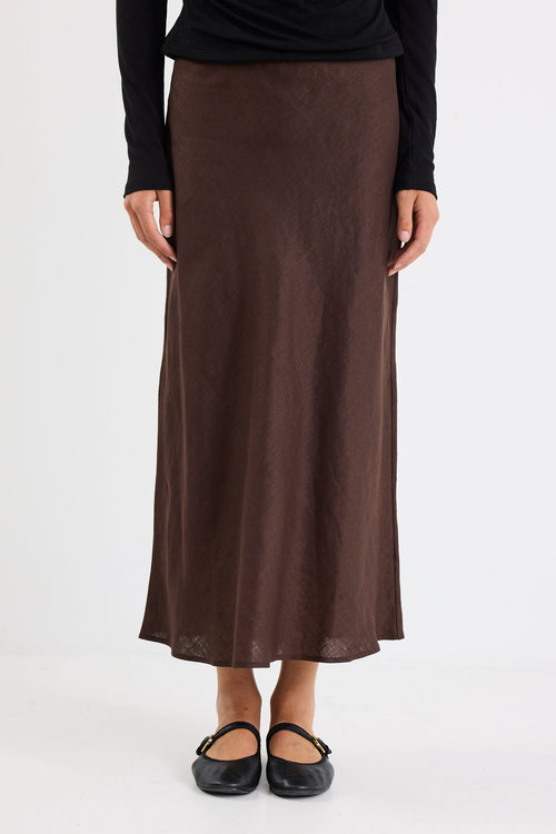 Person wearing a long brown skirt on a white background