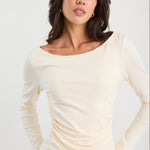 Woman wearing a ruched cream long sleeve top
