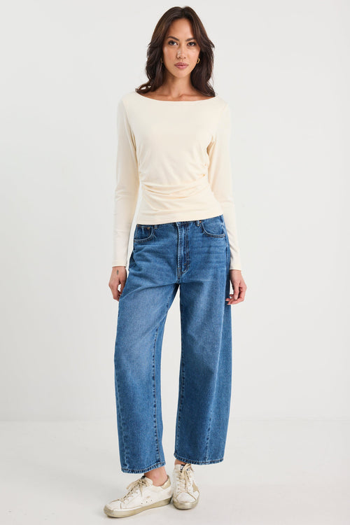 Woman wearing a ruched cream long sleeve top