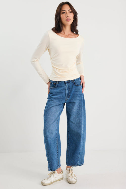 Woman wearing a ruched cream long sleeve top