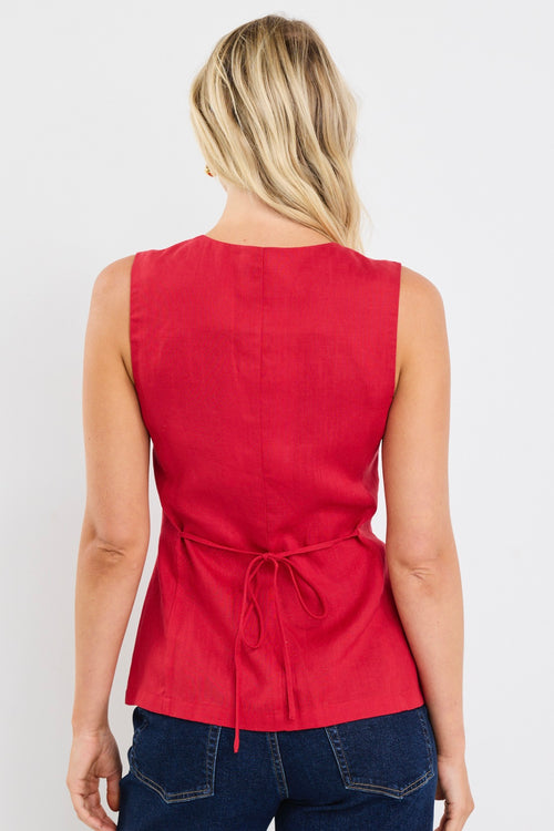 model wears a red linen vest with dark jeans