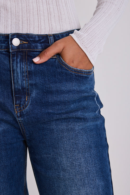Model wears blue jeans with a white top 