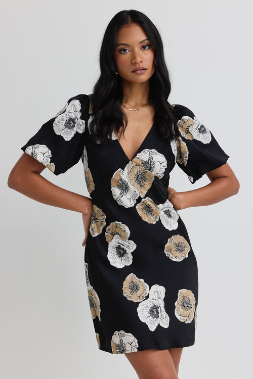 model wears a black floral mini dress