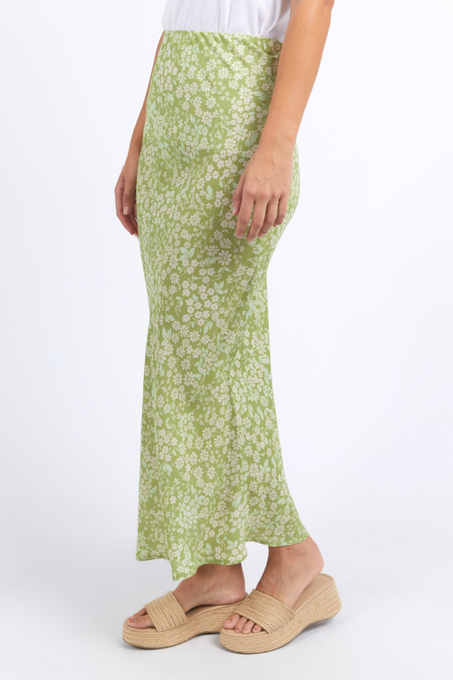 model wears green floral midi skirt and white tank top