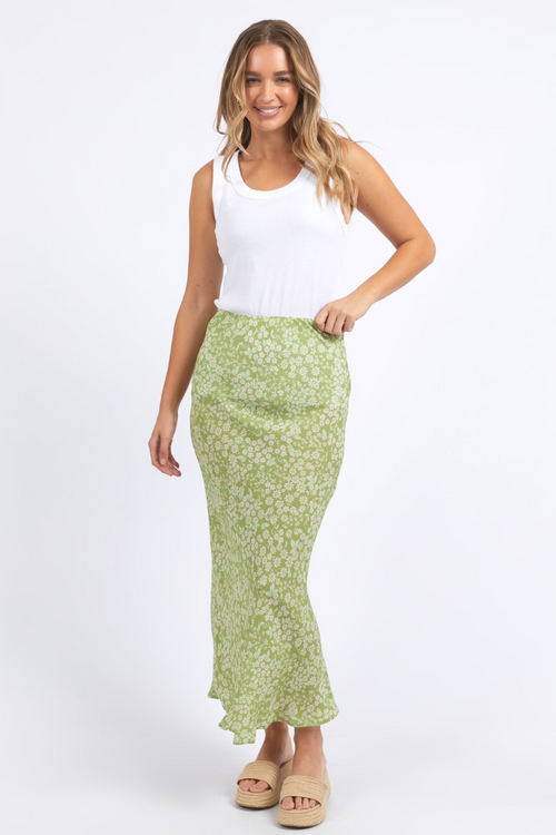 model wears green floral midi skirt and white tank top