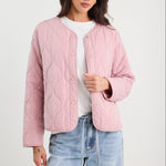 Woman wearing a pink quilted jacket and blue jeans