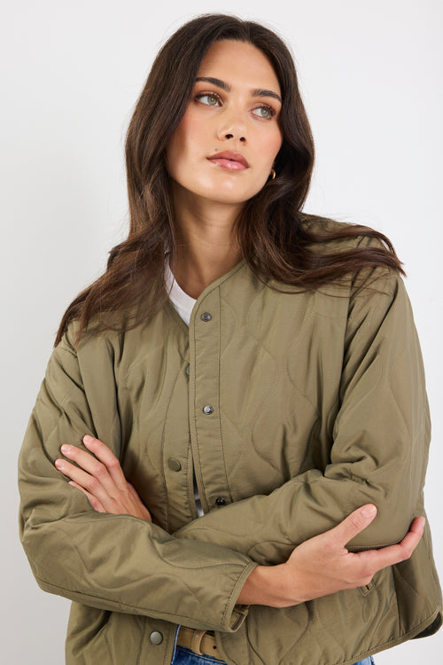 Woman wearing a green jacket against a white background