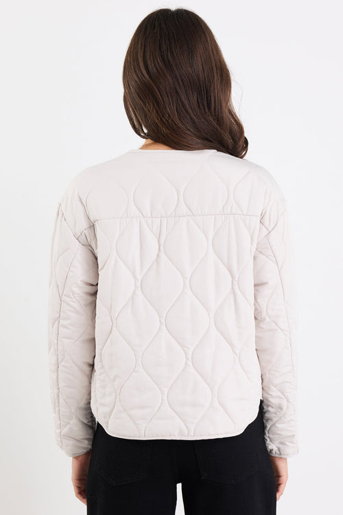 Person wearing a white quilted jacket on a white background