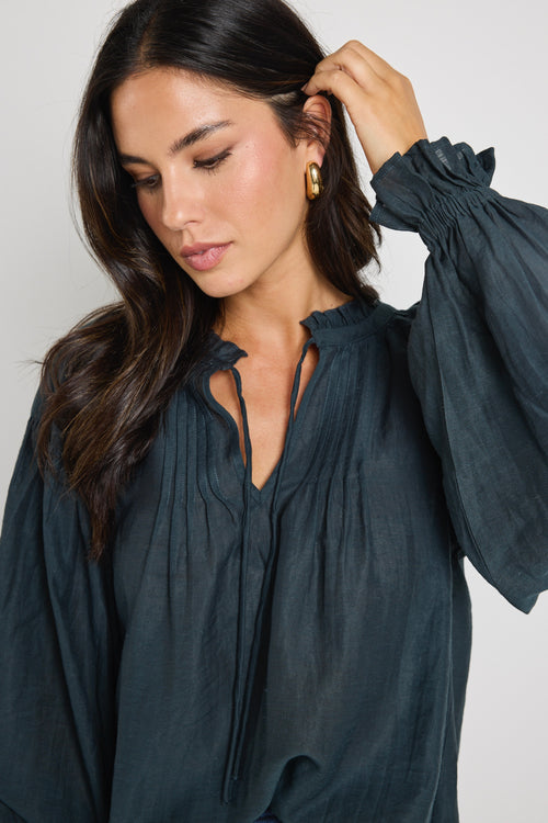 model wears a green long sleeve blouse
