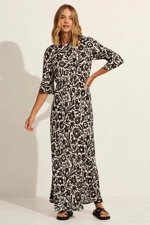 model wears a black floral maxi dress