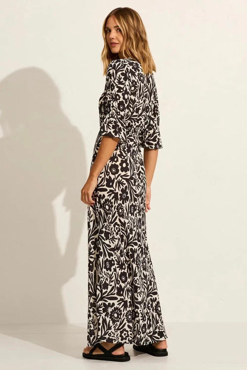 model wears a black floral maxi dress