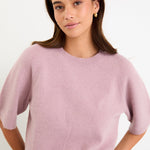 Model wearing a blush short sleeve raglan knit tee with a soft crew neckline and relaxed fit.