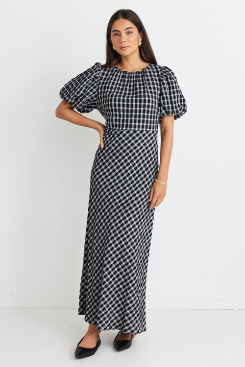 model wears a black and white check maxi dress