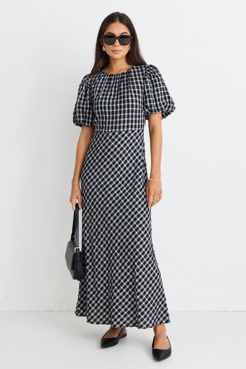 model wears a black and white check maxi dress