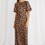 model wears a black floral maxi dress