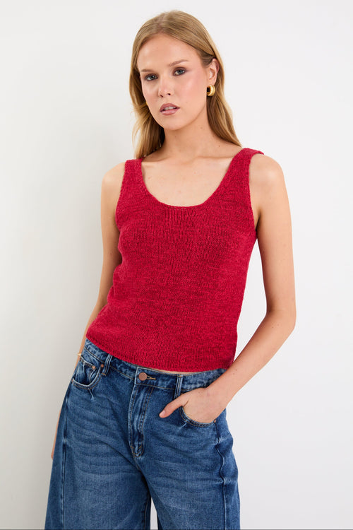 woman wearing a red knit top and blue jeans