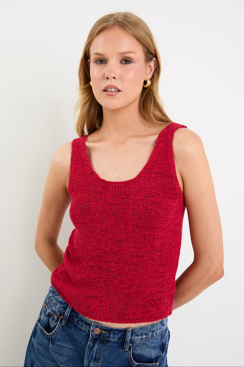 woman wearing a red knit top and blue jeans