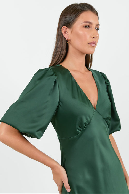 Woman wearing a green dress with short sleeves on a white background