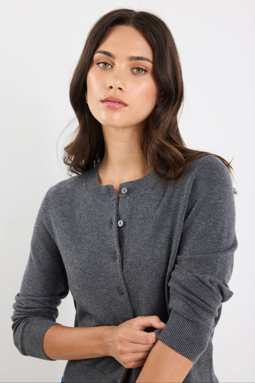 Woman wearing a gray cardigan against a white background